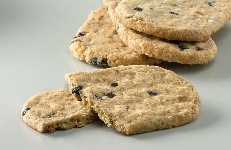 Close-up of Nature Valley Blueberry Biscuit broken in half with three more biscuits stacked in the background..